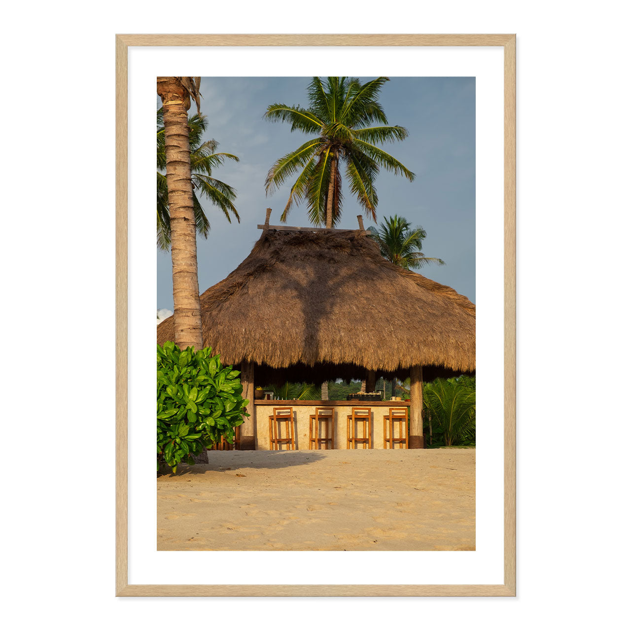 Photo ot a thatched hut with palm trees on a beach