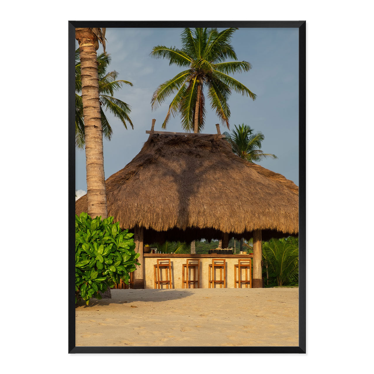 Photo of a thatched hut with palm trees on a beach