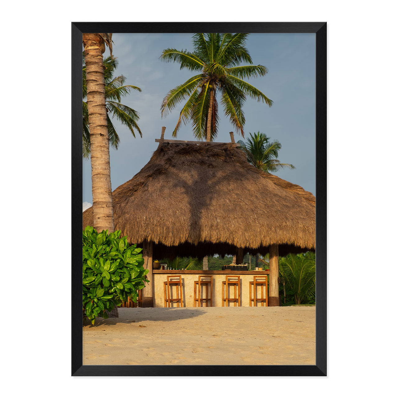 Photo of a thatched hut with palm trees on a beach