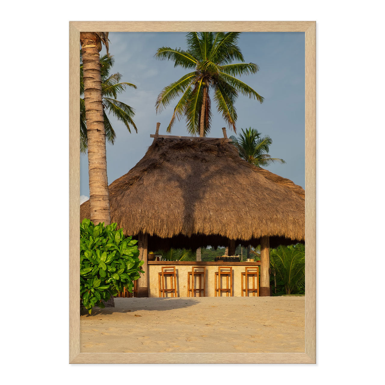 Photo of a thatched hut with palm trees on a beach