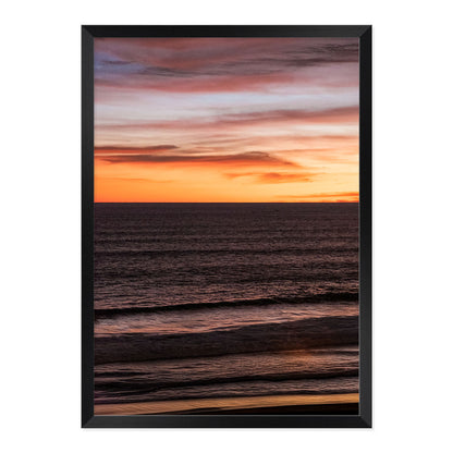 Framed artwork of a sunset over water with a frame.