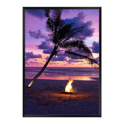 Framed photo of a fire pit by a palm tree on a beach with a sunset sky.