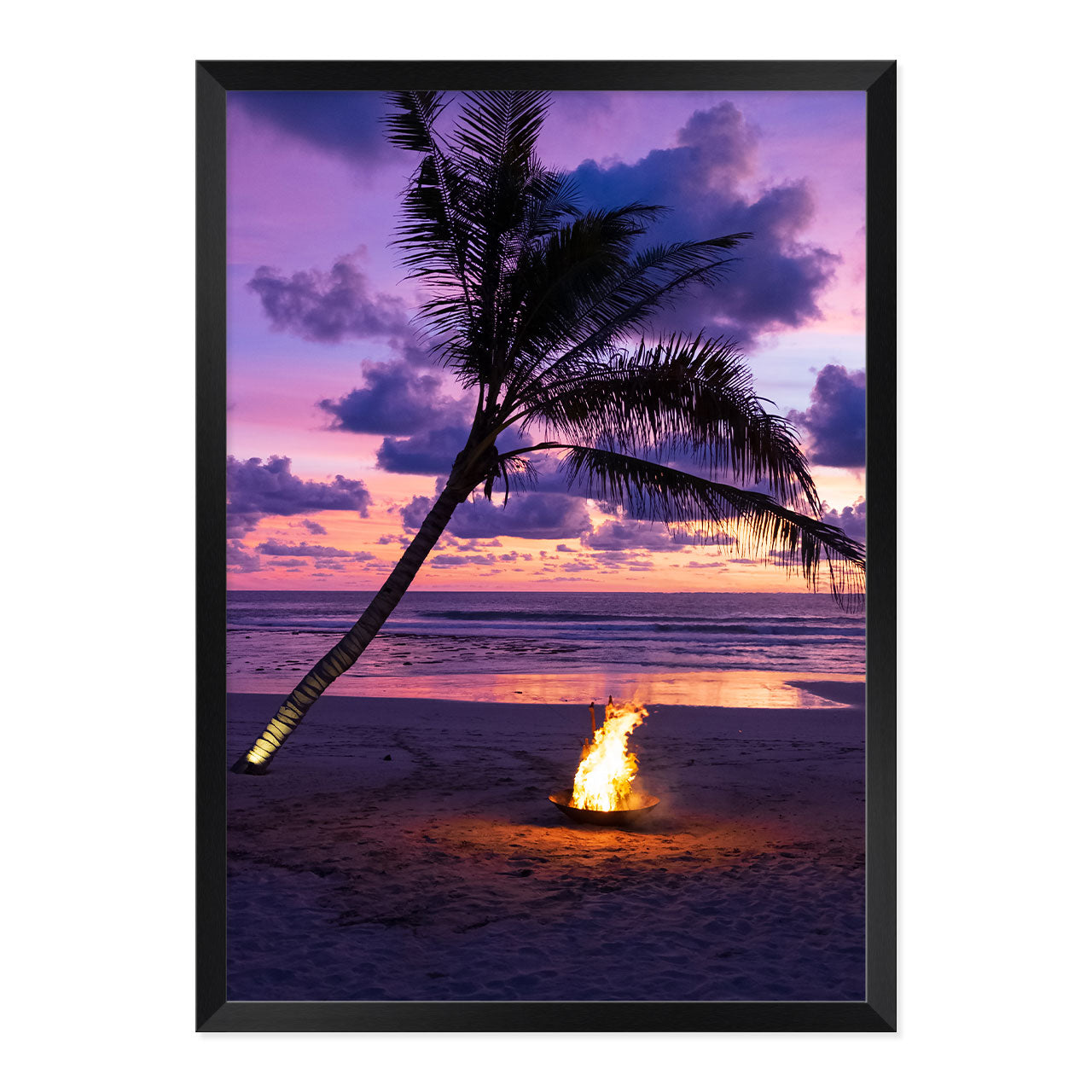 Framed photo of a fire pit by a palm tree on a beach with a sunset sky.