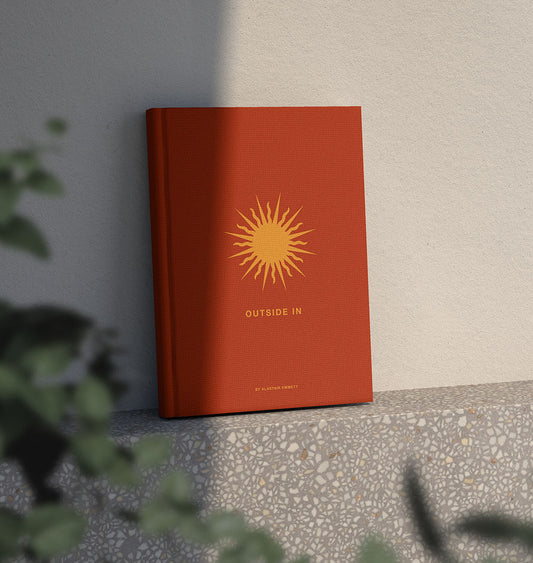 Sunlight hitting Outside In the Book, standing upright on a terrazzo shelf.