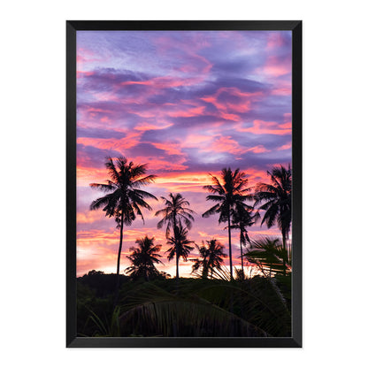 Framed artwork of palm trees against a vibrant purple and pink sunset sky.