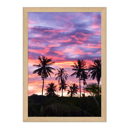 Framed artwork of palm trees against a vibrant purple and pink sunset sky.