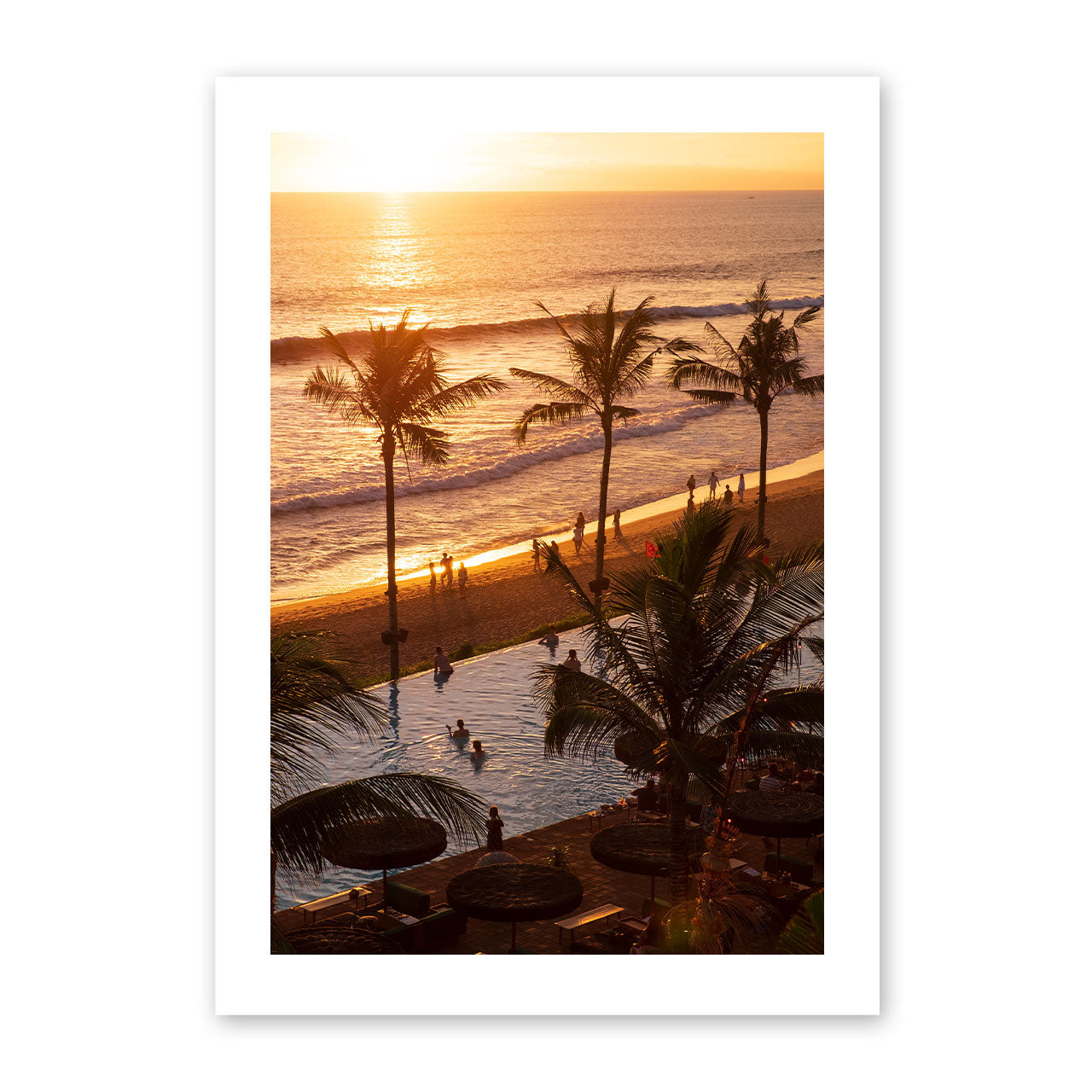 Artwork of a sunset over a beach with palm trees and people.