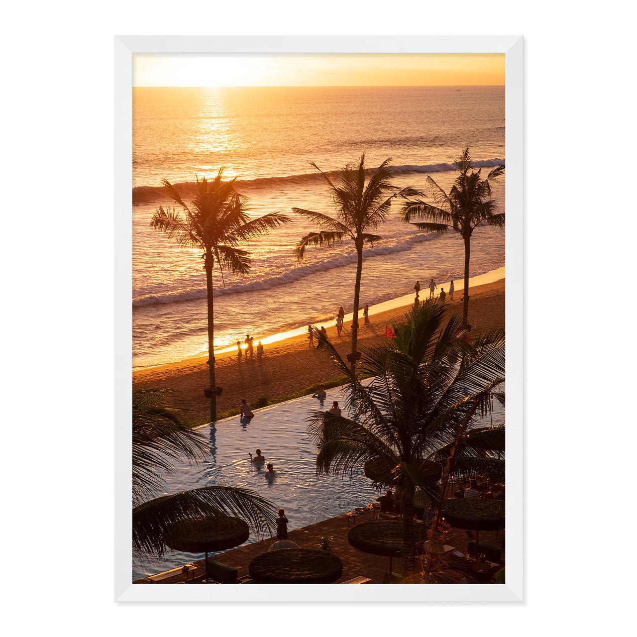 Framed artwork of a sunset over a beach with palm trees and people.