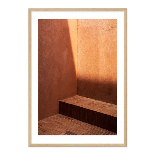 Framed photograph of a room with brown walls and a wooden floor.