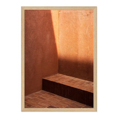 Wooden bench against a textured orange wall with a wooden frame.