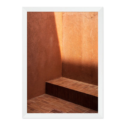 Wooden bench against a textured wall with a white frame