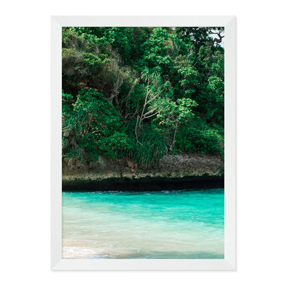 Framed artwork of a tropical landscape with greenery and turquoise water.